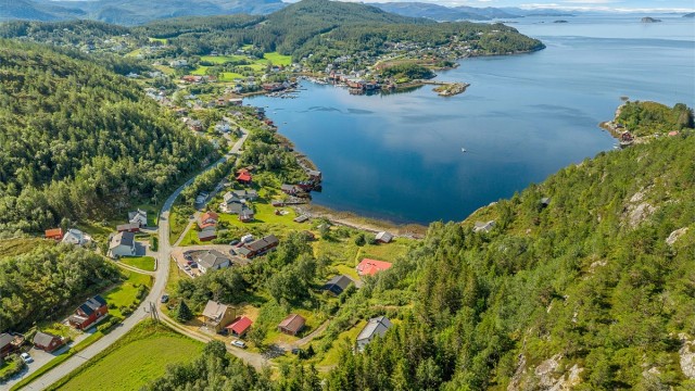 Oversiktsbilde av området som fremhever den idylliske beliggenheten ved Stjørnfjorden og nærheten til Råkvåg sentrum.