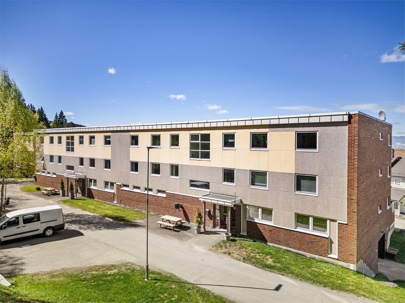 Adkomst via overbygget inngangsparti med callinganlegg og trapp til leilighetens etasjeplan