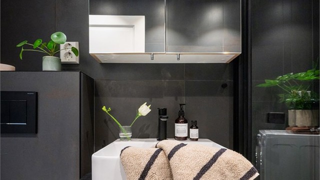 Badet har flislagte overflater, elektrisk gulvvarme og speilskap med integrert belysning.