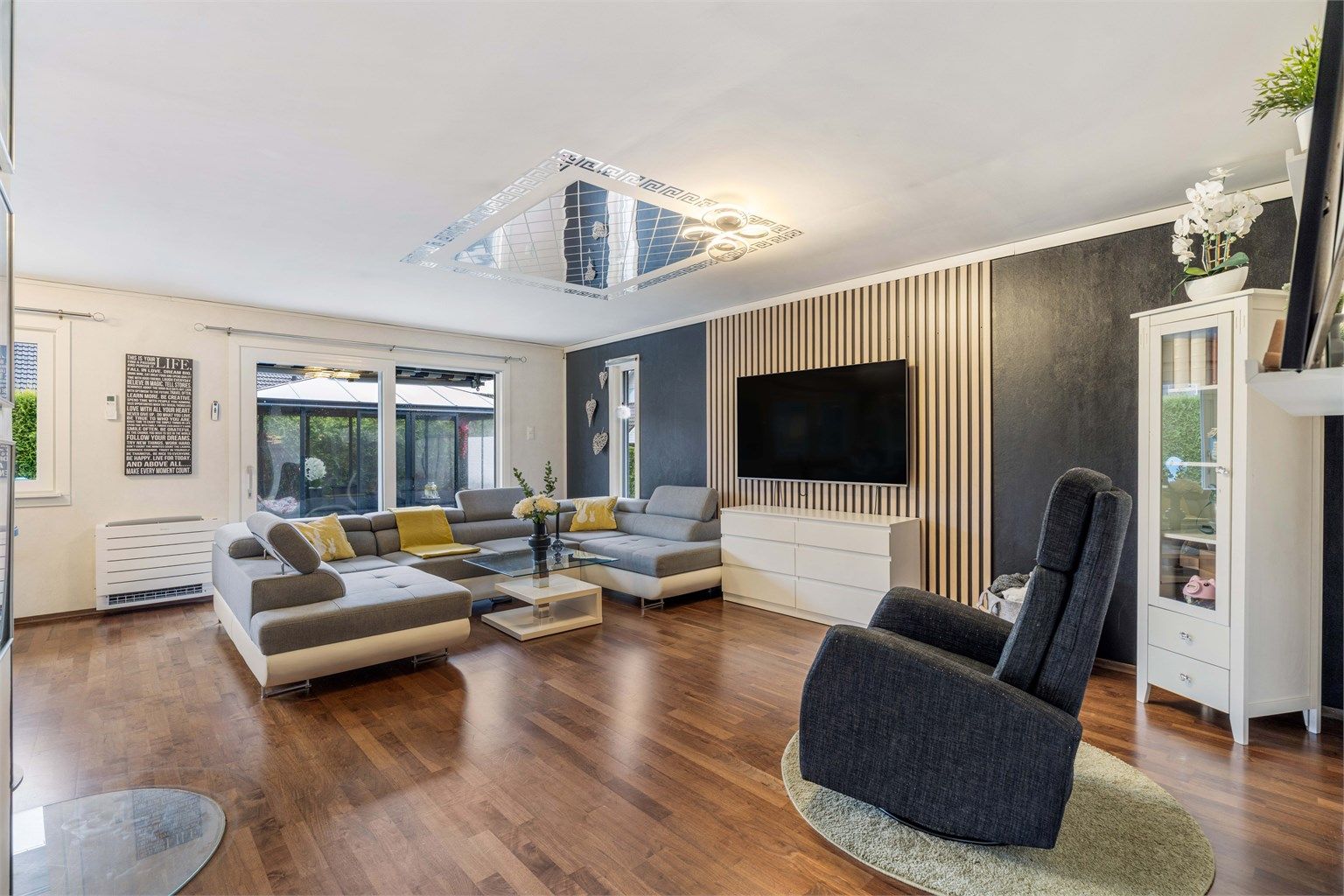 Romslig stue, med ny skyvedør fra 2025 som åpner opp mot terrassen og uteområdet.