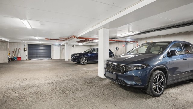 Leiligheten disponerer fast biloppstillingsplass med montert elbillader i felles parkeringskjeller. Fra boligen er det direkte adkomst via innvendig trapp til garasjeanlegget og tilhørende bod. En praktisk og komfortabel løsning.