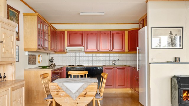 Kjøkkenet ligger naturlig tilbaketrukket fra stuen og er innredet med profilerte fronter og benkeplate av laminat.