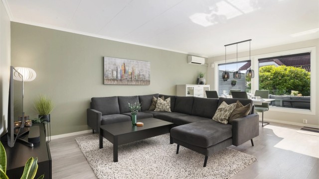 Leiligheten har et åpent og sosialt stue-kjøkkenrom på 32m² med naturlige møbleringssoner. Tvhjørnet er trivelig innredet med sofa og tilhørende bord, samt tv og mediemøblement