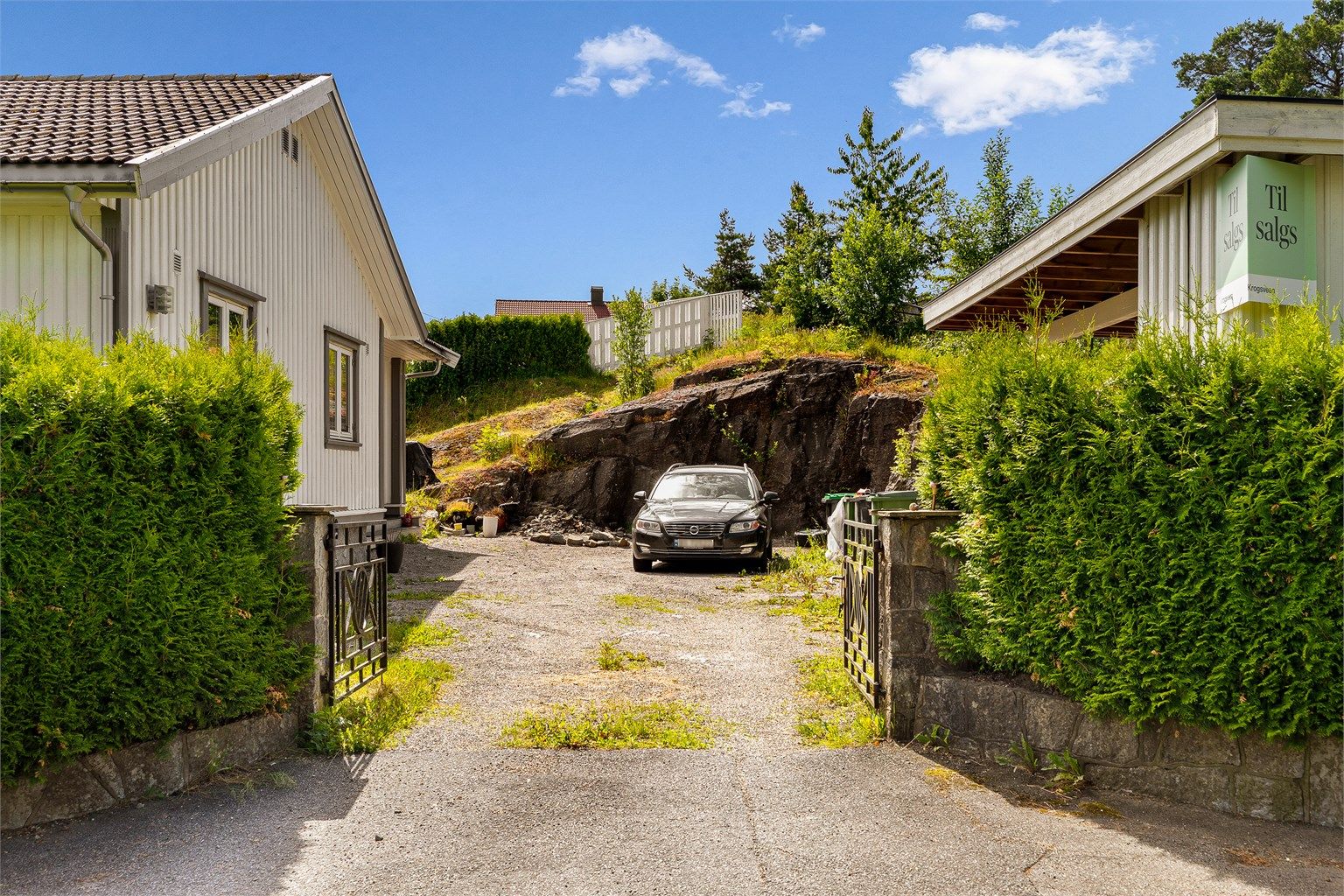 Gruset gårdsplass med parkering for flere biler.