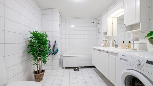 Badet er romslig og lyst med hvit baderomsinnredning og badekar. Fordelerskap for rør-i-rør system er plassert på bad.