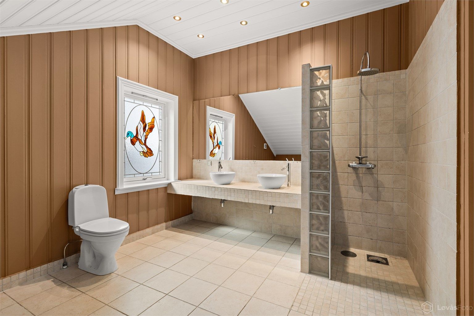 Badet har både en stor dusjnisje og et separat, innbygget badekar. Fliser og innredning ble oppgradert i 2021.
