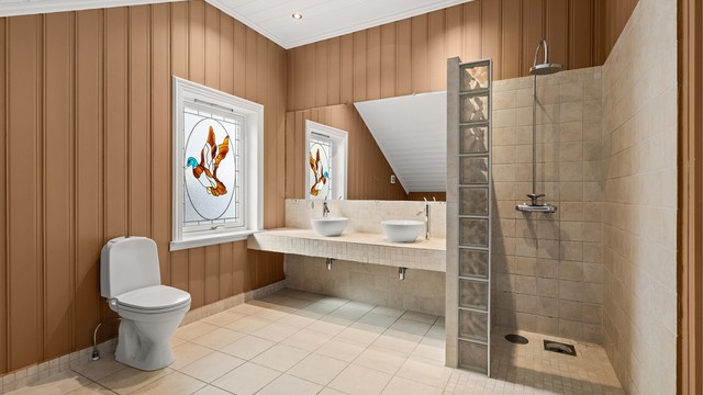 Badet har både en stor dusjnisje og et separat, innbygget badekar. Fliser og innredning ble oppgradert i 2021.