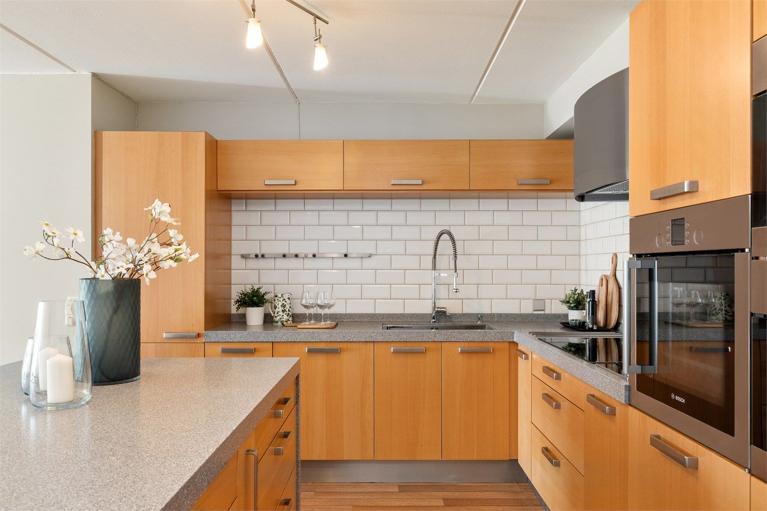 Kjøkkenet er svært godt utnyttet med rikelig skapplass. Vask og platetopp er lagt langs veggen, noe som gir en helt fri arbeidssone på kjøkkenøya.