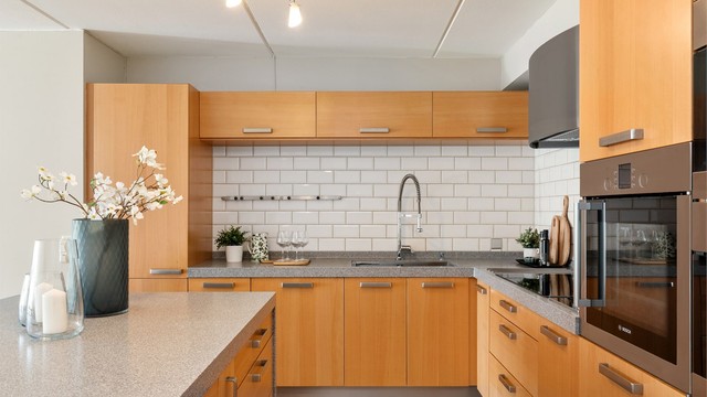 Kjøkkenet er svært godt utnyttet med rikelig skapplass. Vask og platetopp er lagt langs veggen, noe som gir en helt fri arbeidssone på kjøkkenøya.