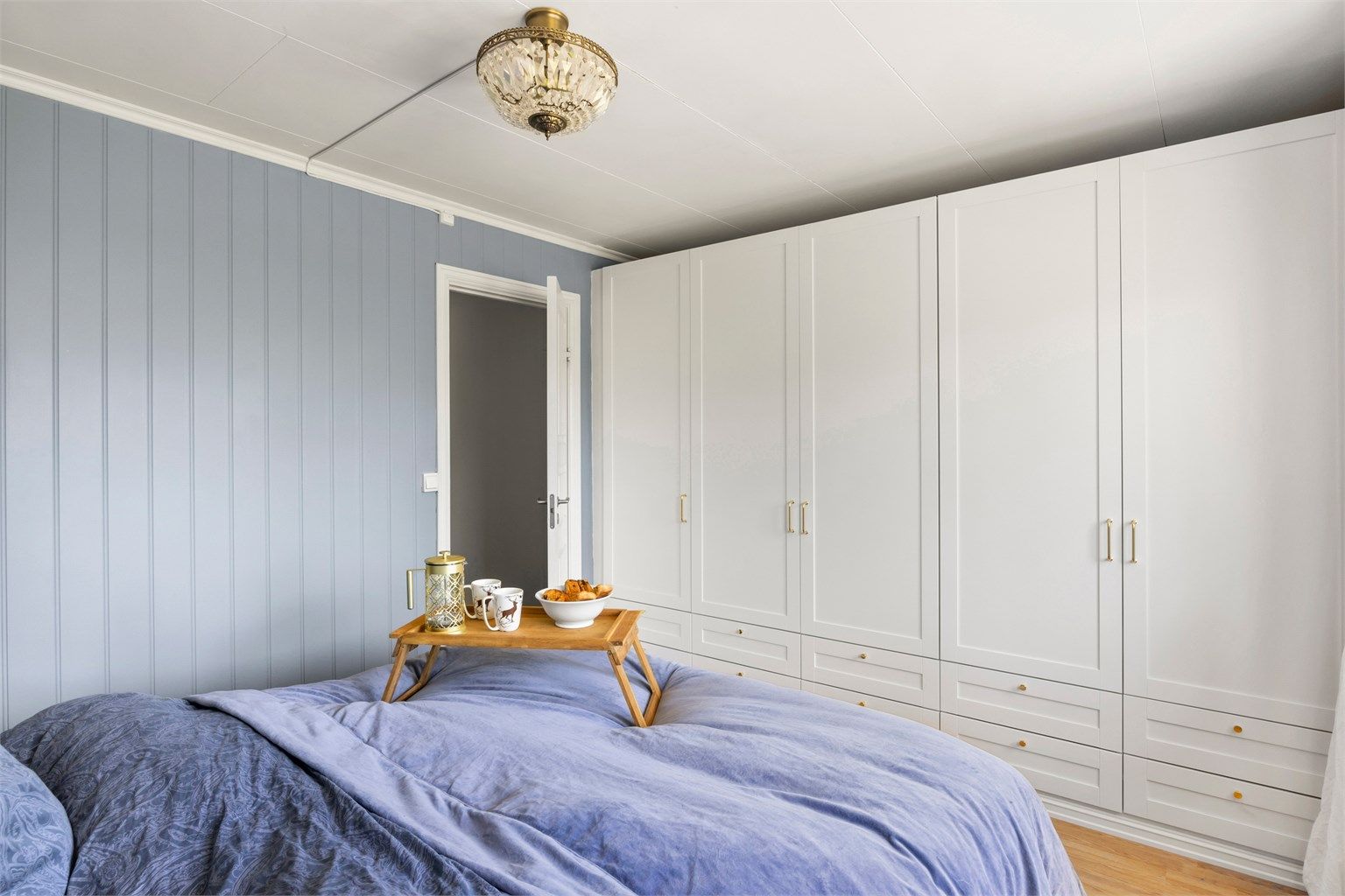 Rommet har også en hel vegg av garderobeskap, med delikate gulldetaljer