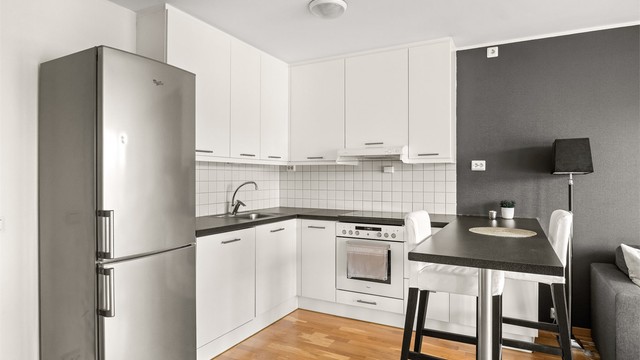 Kjøkkeninnredning med glatte fronter og laminatbenkeplate. Oppvaskmaskin medfølger.
