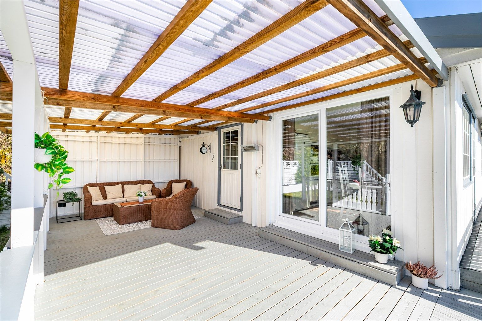 Skyve-/hevedører ble i 2015 satt inn i begge gavlvegger. Dørene gir enkel tilgang til det store utearealet rundt boligen - denne siden rett fra kjøkkenet.