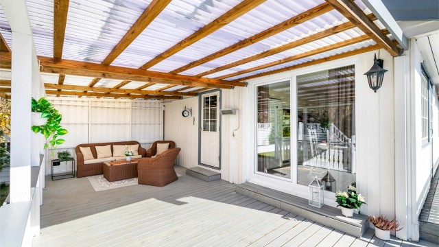 Skyve-/hevedører ble i 2015 satt inn i begge gavlvegger. Dørene gir enkel tilgang til det store utearealet rundt boligen - denne siden rett fra kjøkkenet.