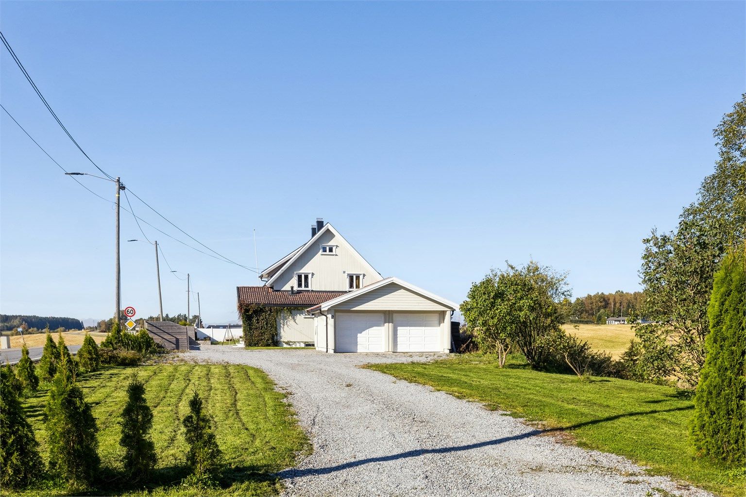 Tomten er opparbeidet med gruslagt gårdsplass, stor hage med gressplen og diverse beplantning