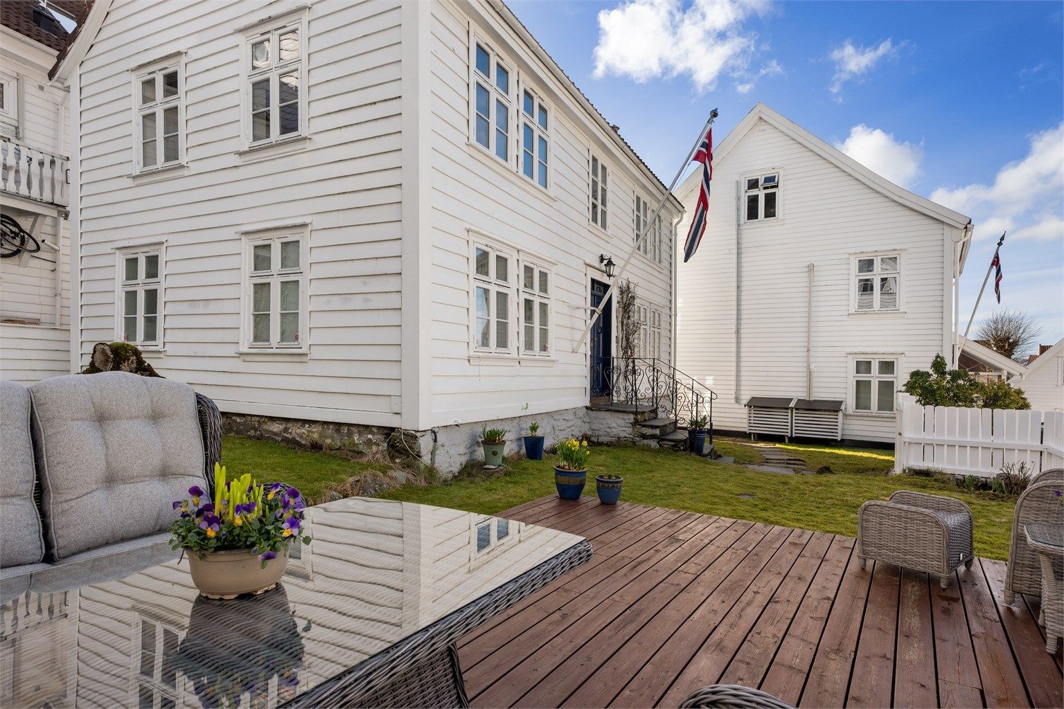 De vakre krysspostvinduer, hvit trekledning og klassiske detaljer bidrar til å bevare husets historiske sjarm.