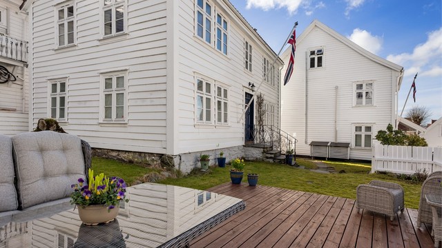 De vakre krysspostvinduer, hvit trekledning og klassiske detaljer bidrar til å bevare husets historiske sjarm.