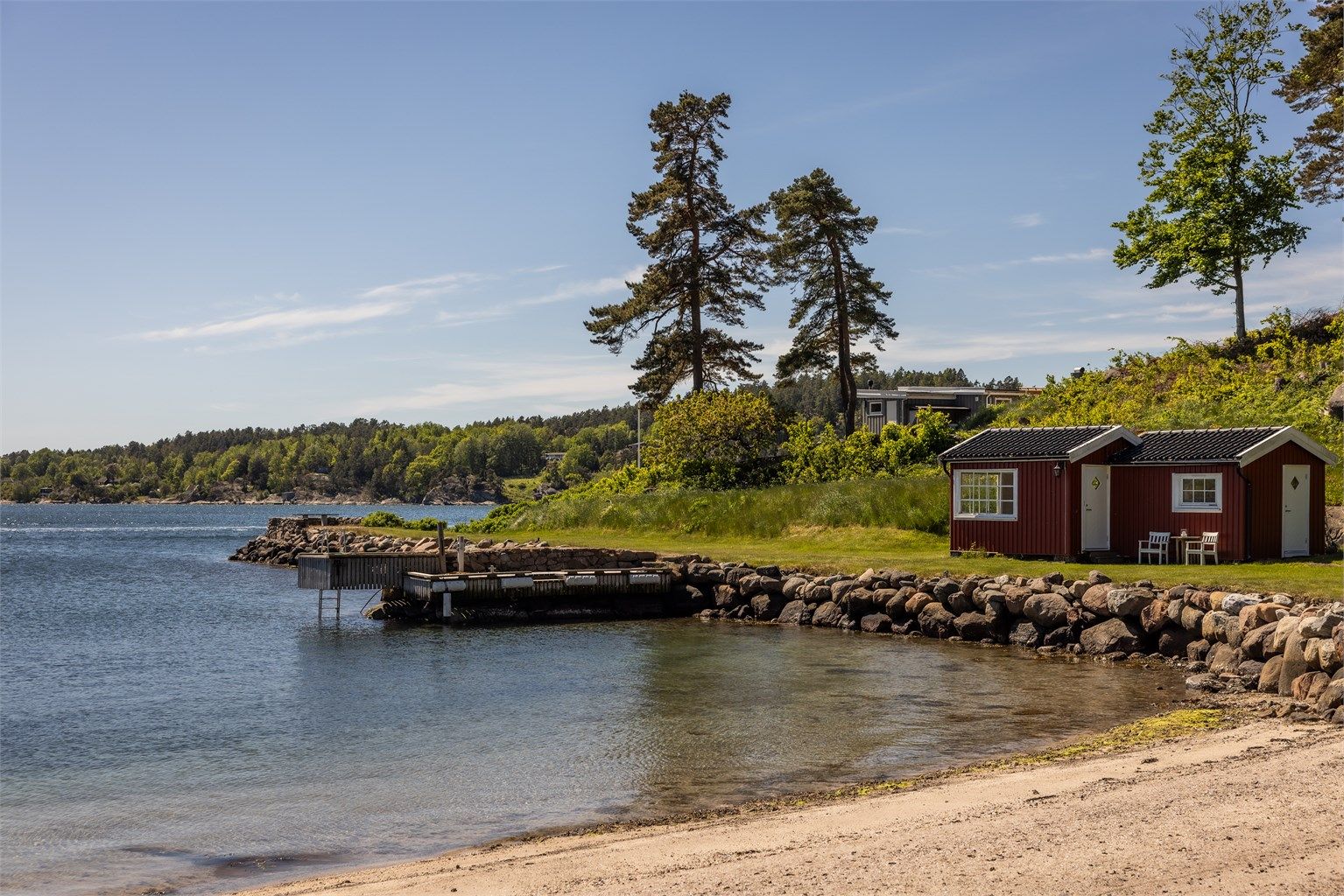Ved vannkanten ligger en praktisk utebod og egen brygge.