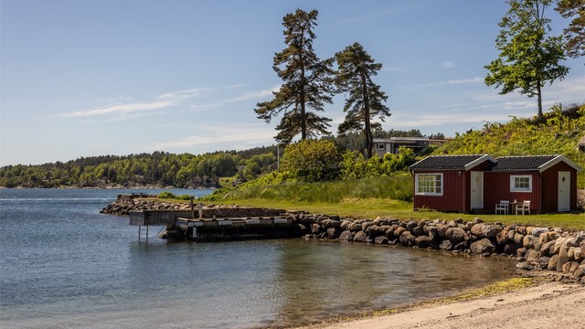 Ved vannkanten ligger en praktisk utebod og egen brygge.