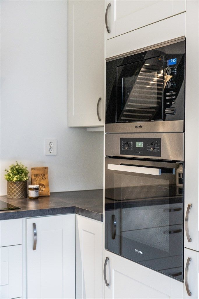 Kjøkkeninnredningen har profilerte fronter og er utstyrt med integrert stekeovn, mikrobølgeovn, induksjonstopp, kjøl/frys og oppvaskmaskin.