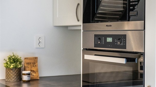 Kjøkkeninnredningen har profilerte fronter og er utstyrt med integrert stekeovn, mikrobølgeovn, induksjonstopp, kjøl/frys og oppvaskmaskin.