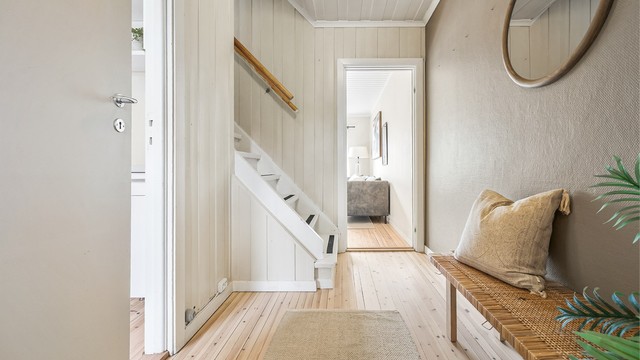 Hallen binder sammen første etasje og har trapp opp til soverommene i andre etasje.