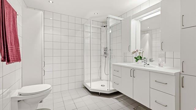 Leiligheten har et romslig bad/wc med klassiske hvite fliser og tidløs baderomsinnredning med svært god plass for det som trengs på et baderom