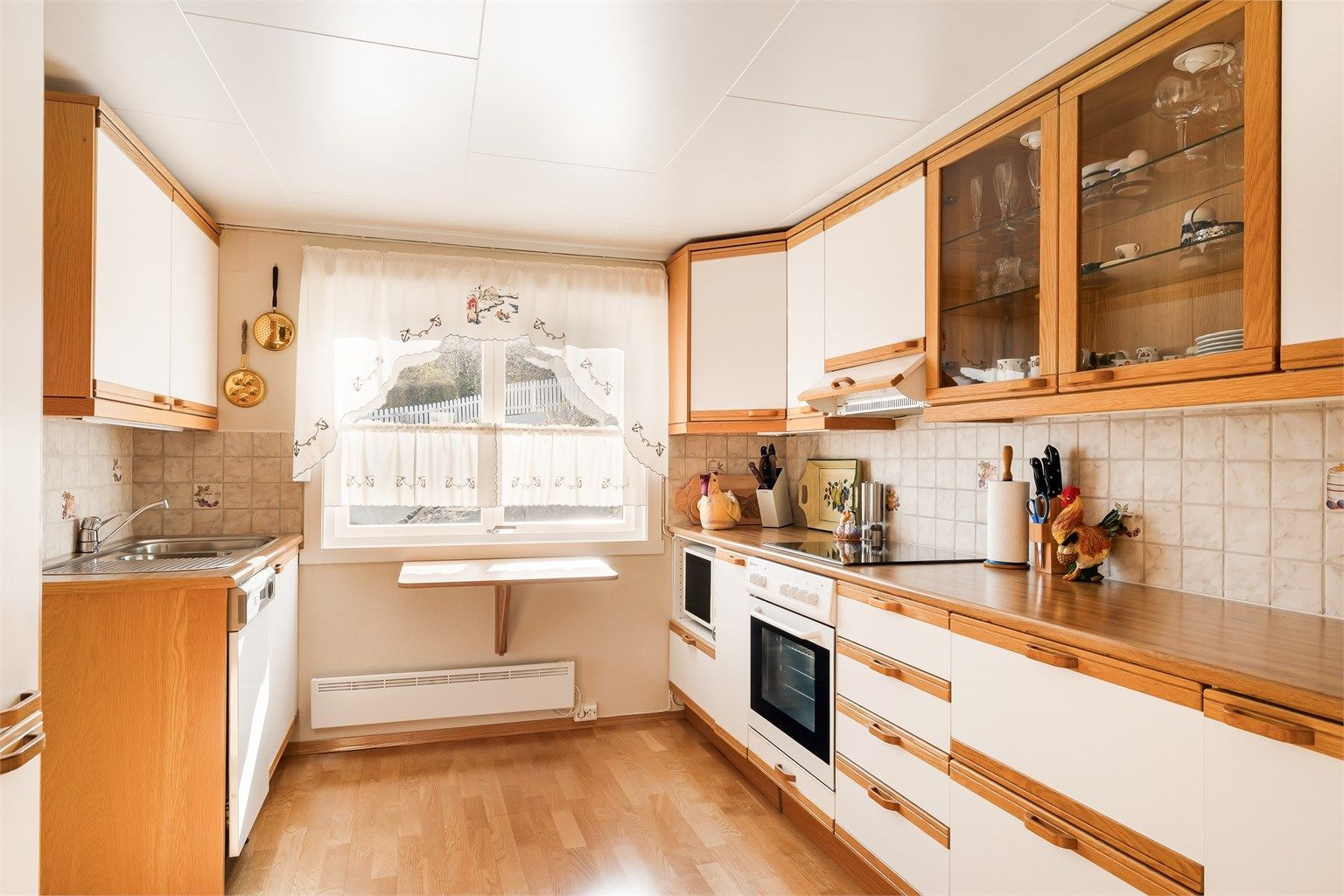 Kjøkkeninnredning har rikelig med skap, skuffer og benkeplass.