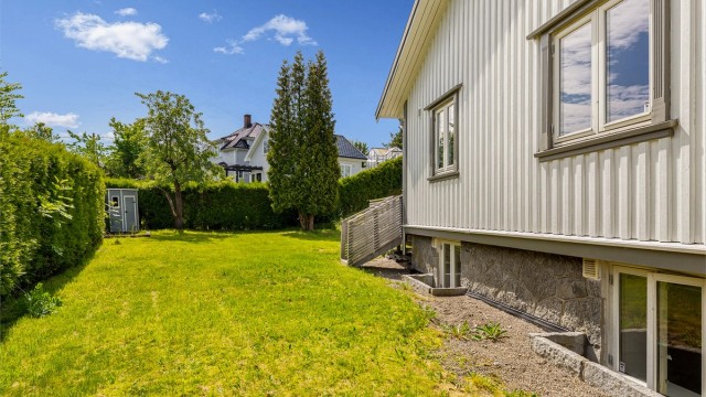 Stor hage som strekker seg rundt boligen.