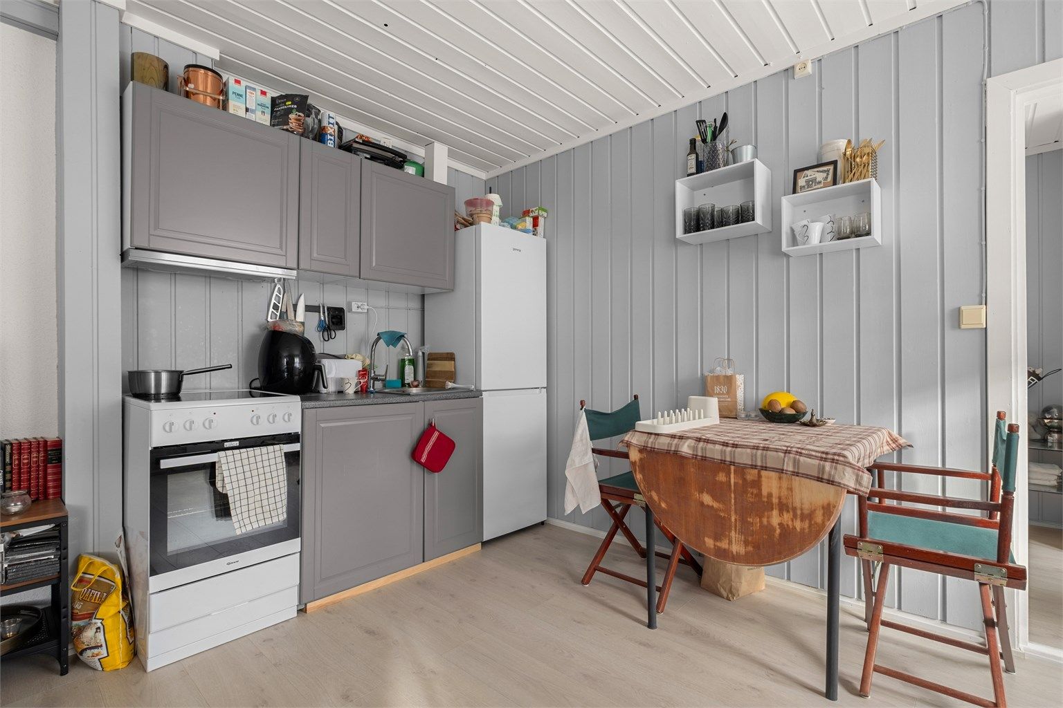 Kjøkkenet er kompakt og funksjonelt, med plass til et lite spisebord.