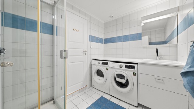 Bad med vegghengt servant og opplegg for vaskemaskin/tørketrommel.