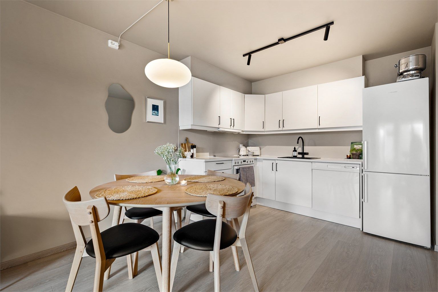 Åpen og sosial kjøkkenløsning med god tilknytning til boligens øvrige oppholdsarealer. Kjøkkeninnredning fra byggeår med tidløse, glatte fronter og laminert benkeplate. 