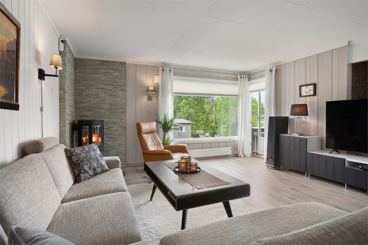 Lys og fin stue med flott peisovn og utgang til terrasse 