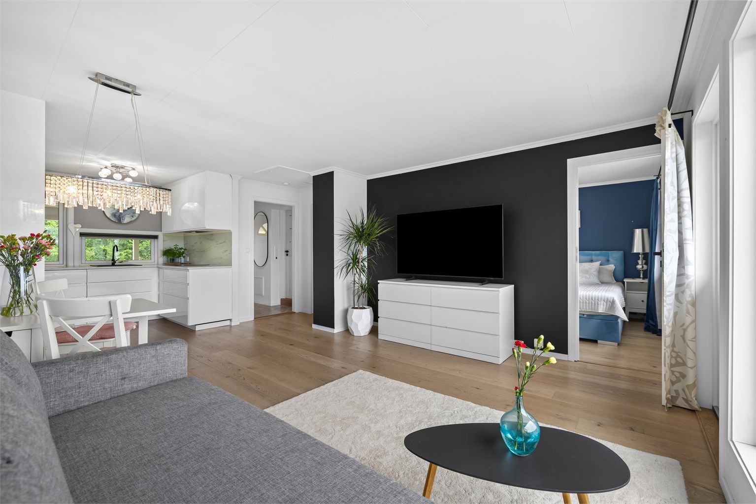 Stue og kjøkken ligger i en åpen løsning som skaper et sosialt og innbydende allrom med naturlig plass for både avslapning og hyggelige måltider.