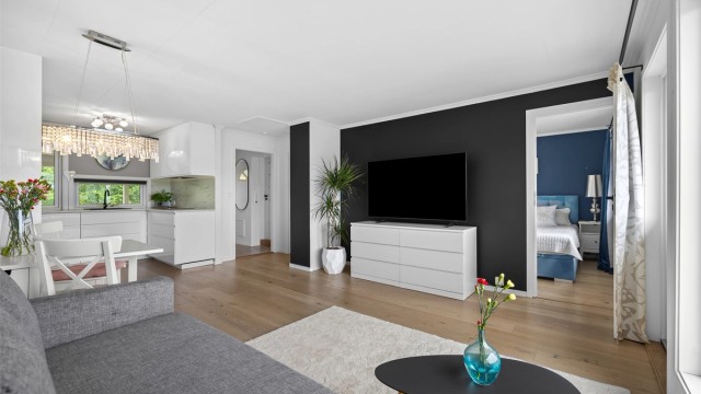 Stue og kjøkken ligger i en åpen løsning som skaper et sosialt og innbydende allrom med naturlig plass for både avslapning og hyggelige måltider.