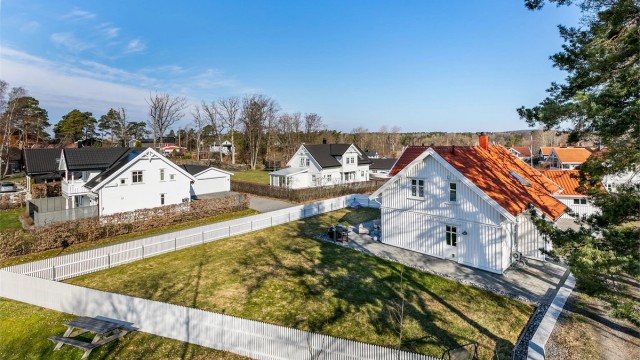 Hvitmalt stakittgjerde rammer pent inn den store, men lettstelte hagen.