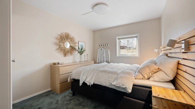 Soverom I er delikat og lunt med teppe på gulv og malte vegger. Det er god plass til stor seng samt nattbord.