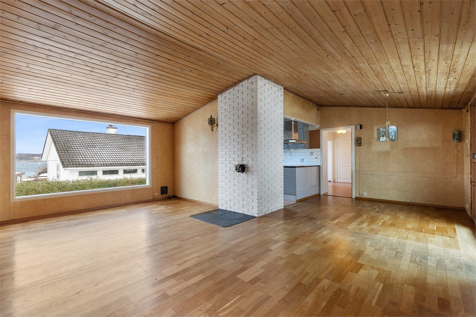 Stuen er romslig og har et stort vindu som rammer inn utsikten mot sjøen.