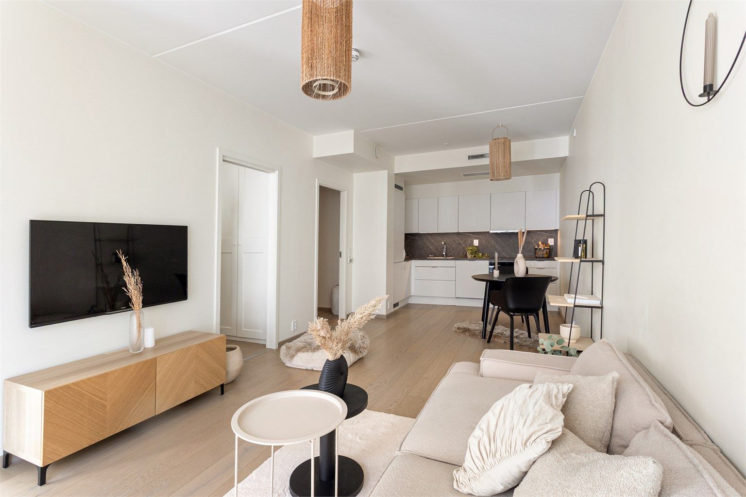 Den åpne løsningen mellom stue og kjøkken gir en sosial og innbydende sone for både hverdag og gjester.