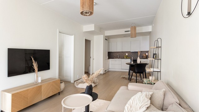 Den åpne løsningen mellom stue og kjøkken gir en sosial og innbydende sone for både hverdag og gjester.