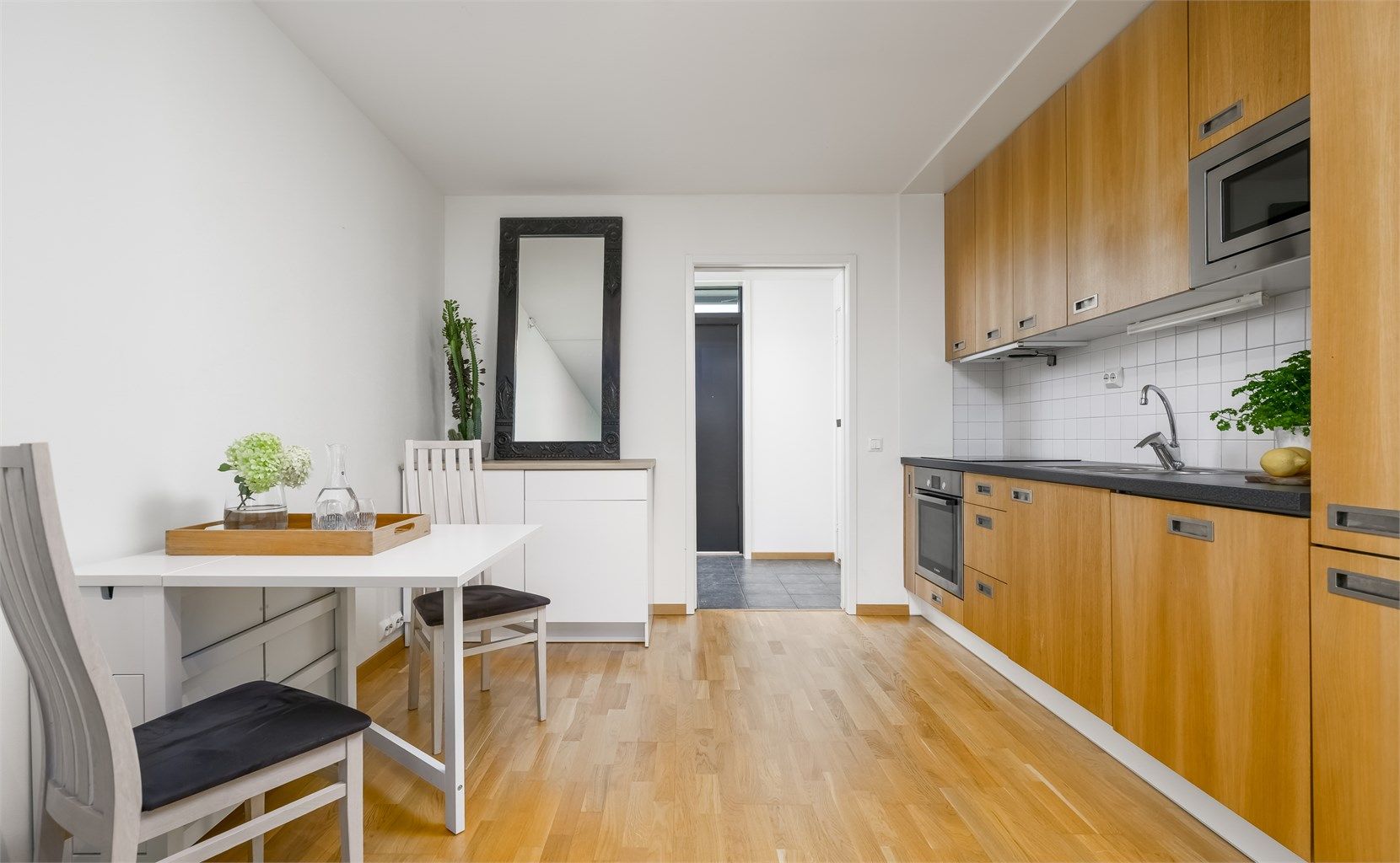 Kjøkkenet har slette fronter og ekstra høye overskap, og er utstyrt med integrert stekeovn, koketopp, oppvaskmaskin, kjøleskap og mikrobølgeovn.