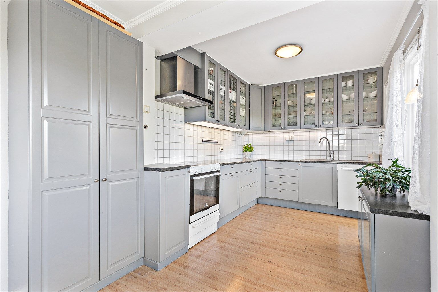 IKEA kjøkken fra 2006 med klassisk innredning og god funksjonalitet. Profilerte fronter og laminert benkeplate. Kjøkkenet er utstyrt med kjøleskap, fryseskap, komfyr med platetopp og oppvaskmaskin, samt kjøkkenventilator.