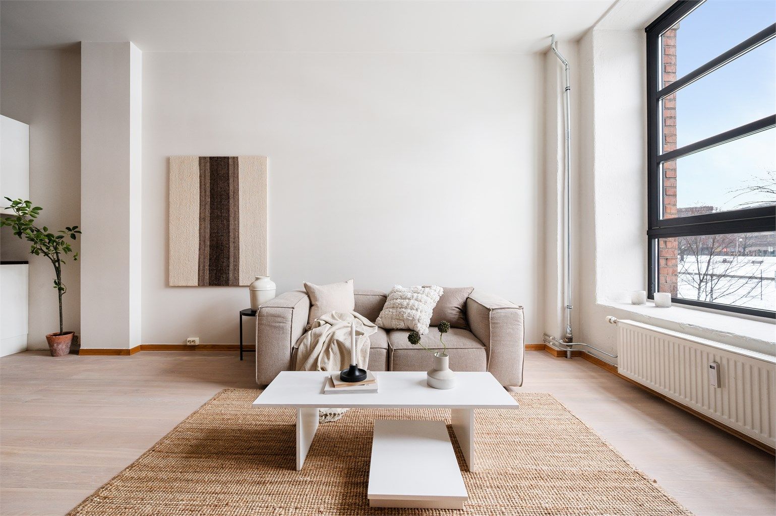  I stuen har du plass til stor sofasone og spisegruppe. Leiligheten har et unikt og stort vindu mot idylliske Akerselva, som slipper inn rikelig med lys og forsterker den gode romfølelsen sammen med takhøyden. 