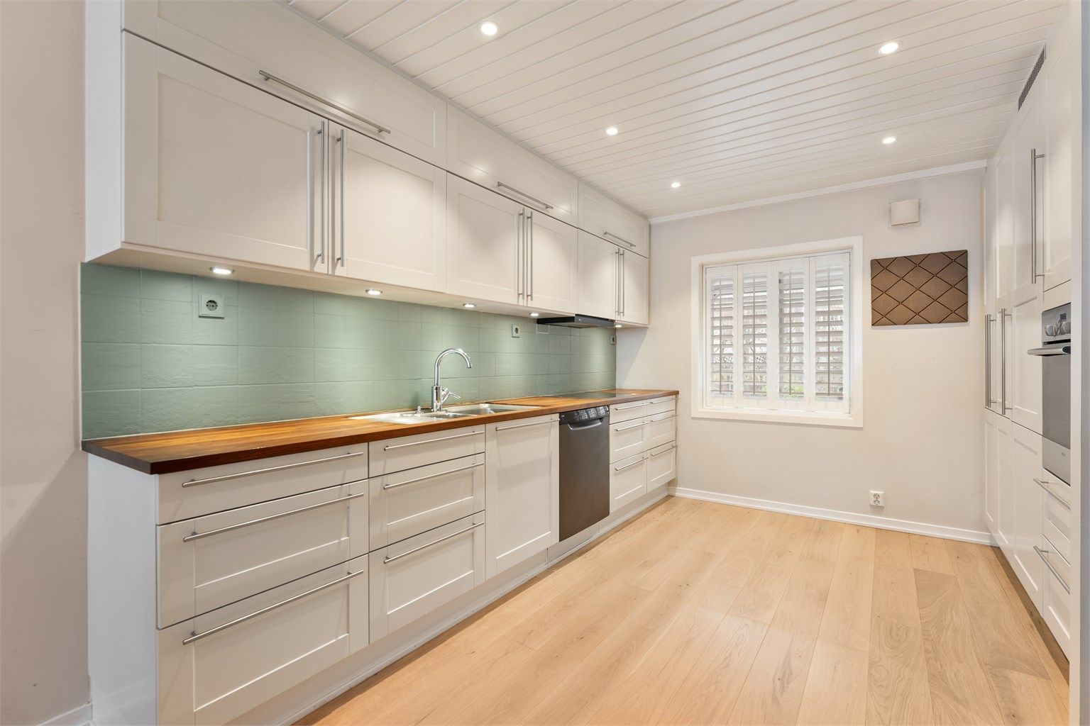 Kjøkkeninnredning fra HTH (2004) med profilerte fronter, rikelig med skap- og benkeplass.