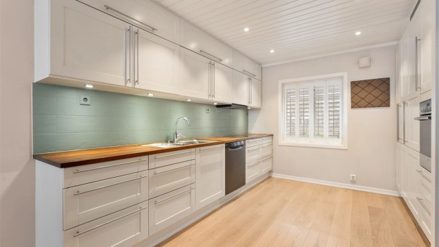 Kjøkkeninnredning fra HTH (2004) med profilerte fronter, rikelig med skap- og benkeplass.