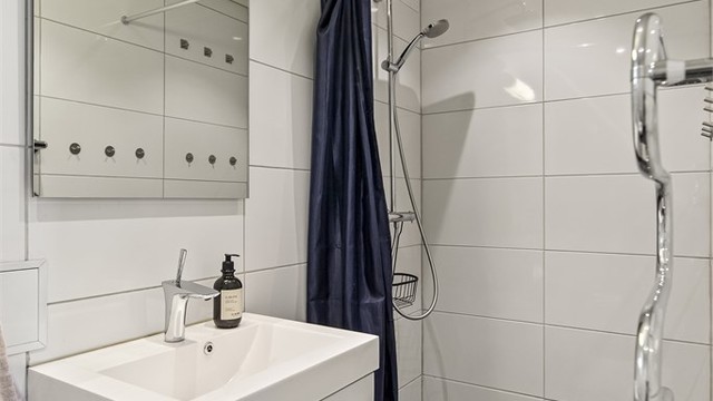 Badet i første etasje har flislagt gulv med gulvvarme og innfelte downlights i taket.