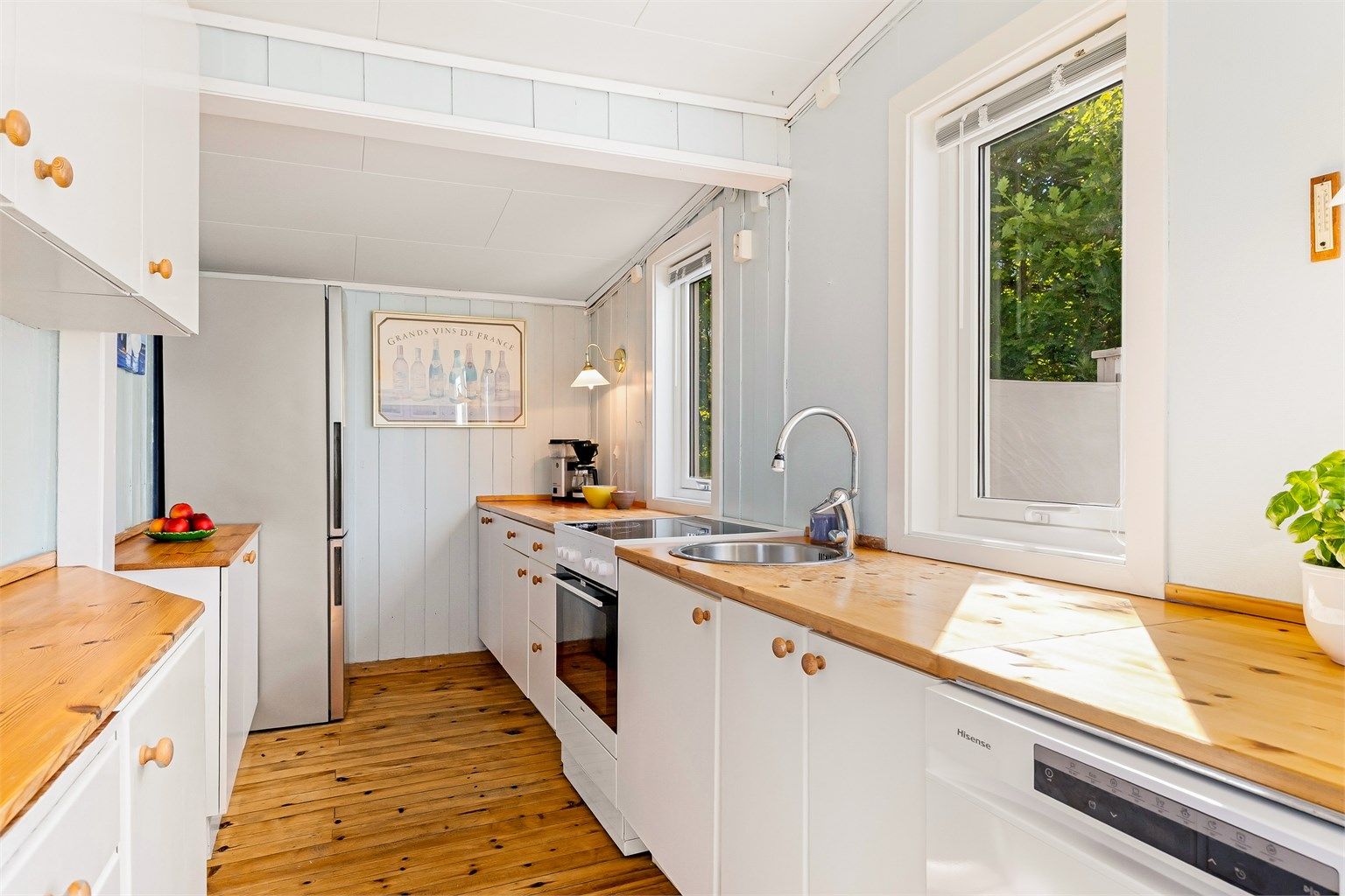 Innredningen har slette fronter og benkeplate i treverk. Det er rikelig med benkeplass. Det er plass til kjøleskap, oppvaskmaskin og komfyr. 