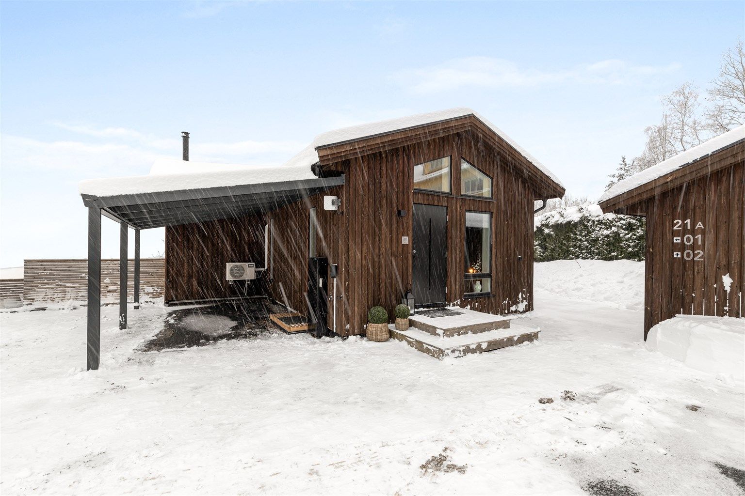 Moderne fasade med carport og elbillader.