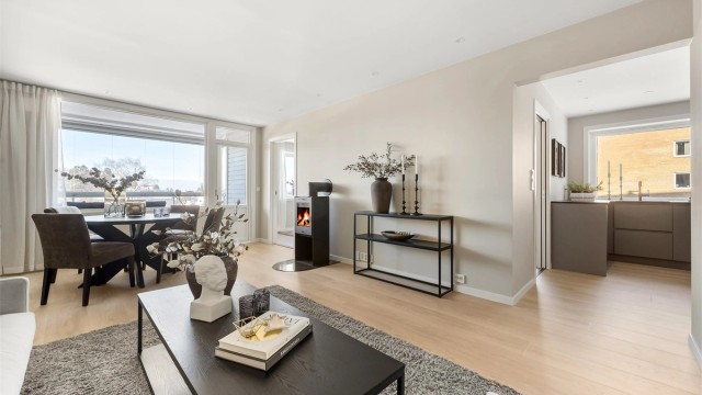 Den delvis åpne løsningen mellom stue og kjøkken skaper en sosial atmosfære.