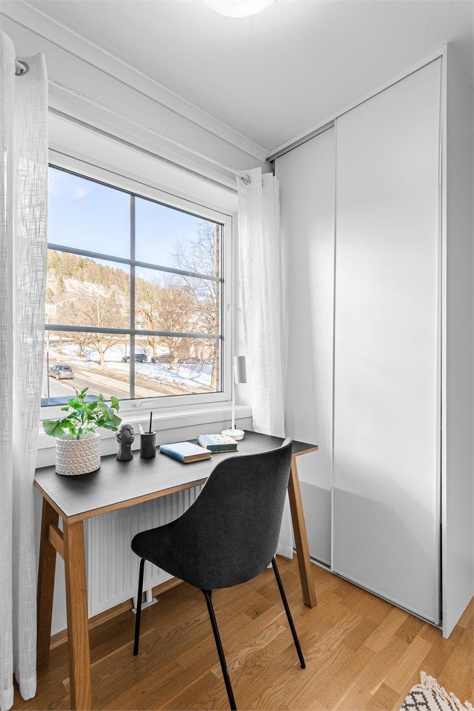 Soverom 2 med skyvedørsgarderobeskap og fin plass for kontorpult. Utsikt mot Bragernes kirke.