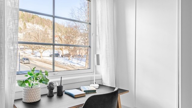 Soverom 2 med skyvedørsgarderobeskap og fin plass for kontorpult. Utsikt mot Bragernes kirke.